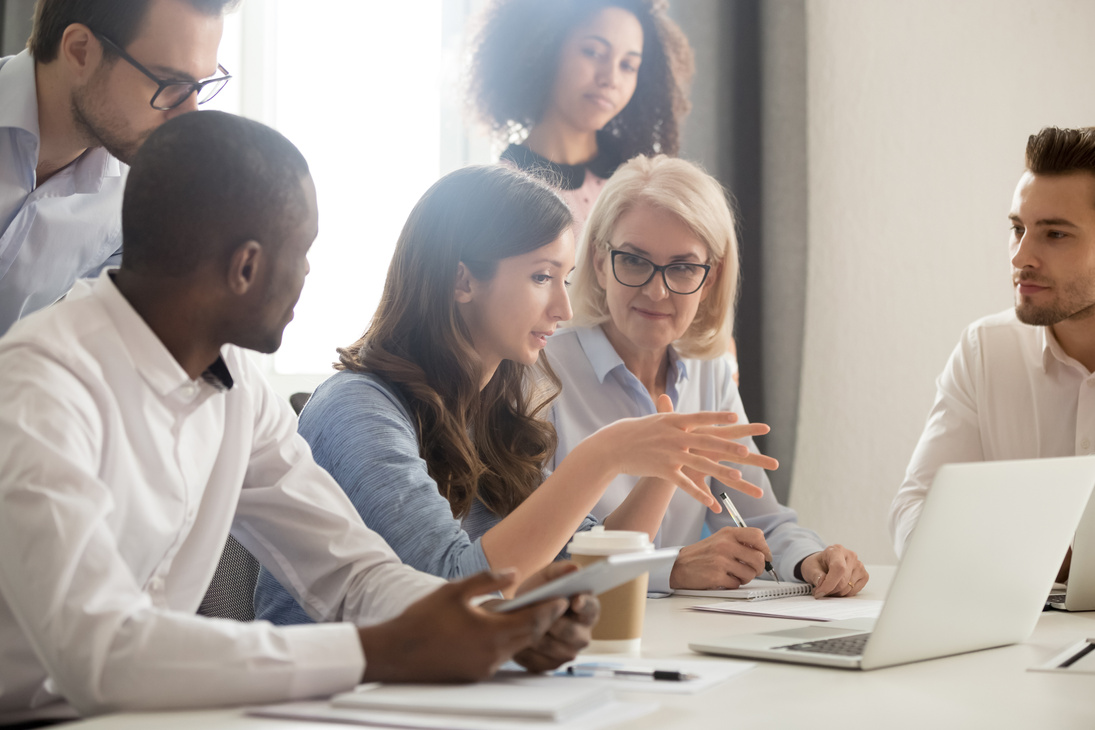 Female mentor teaching employees group analyzing online project explaining strategy